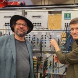 Prof. Dr. Eberhard Waffenschmidt (1.v.l.) und Prof. Dr. Ingo Stadler (2.v.l.) vom Institut für Elektrische Energietechnik (IET) der Technischen Hochschule Köln haben mit dem GridMaximizer ein System entwickelt, das die Auslastung bestehender Stromnetze erhöht (Foto TH Köln).